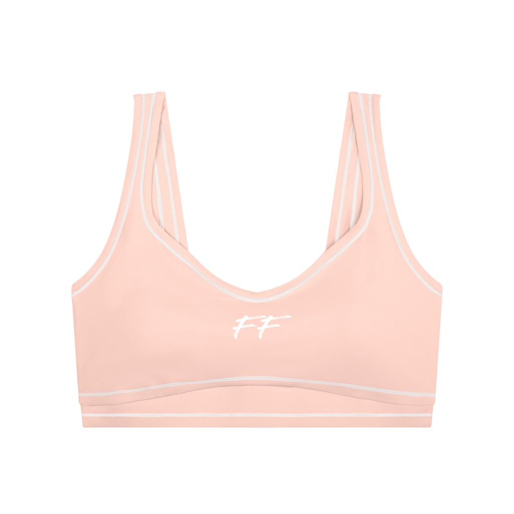 Women's light pink nylon blend yoga sports bra with white logo and seams, featuring Double Take Topstitching details.