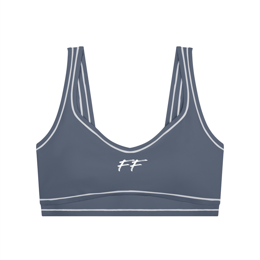 Double Take Topstitching sports bra in slate blue with white trim, elastic hem, and subtle logo detail on front.