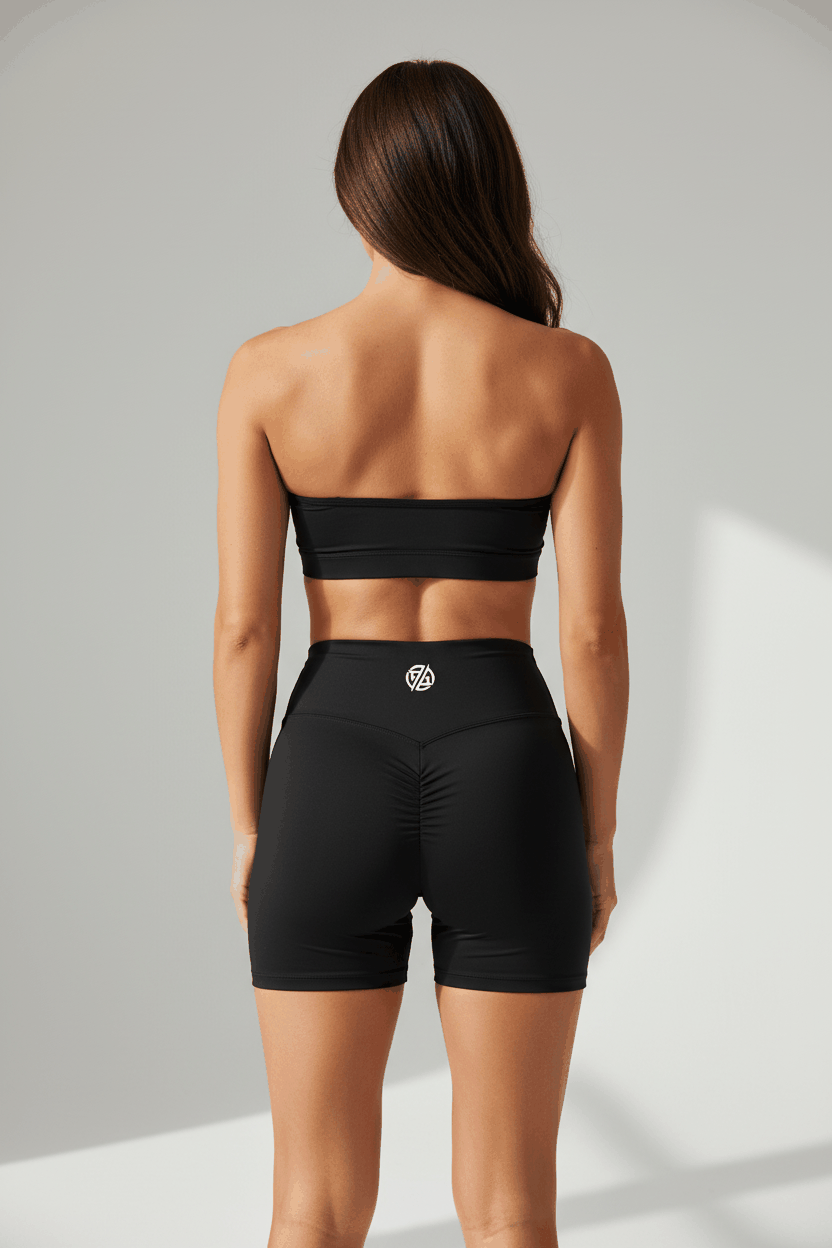 Black women's ruched blend high-waisted biker shorts from FyneFIT, shown from the back with a close-up view.
