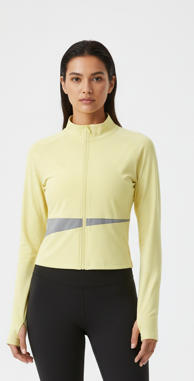 Fitness model wearing FyneFIT light yellow and light gray paneled yoga jacket on a plain studio background