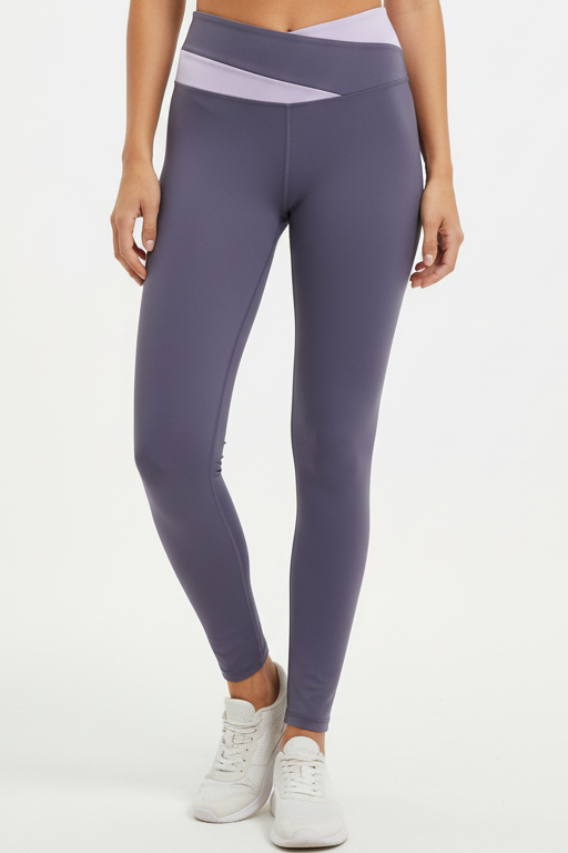 Fitness model wearing FyneFIT deep purple and light purple color block yoga leggings on a plain studio background