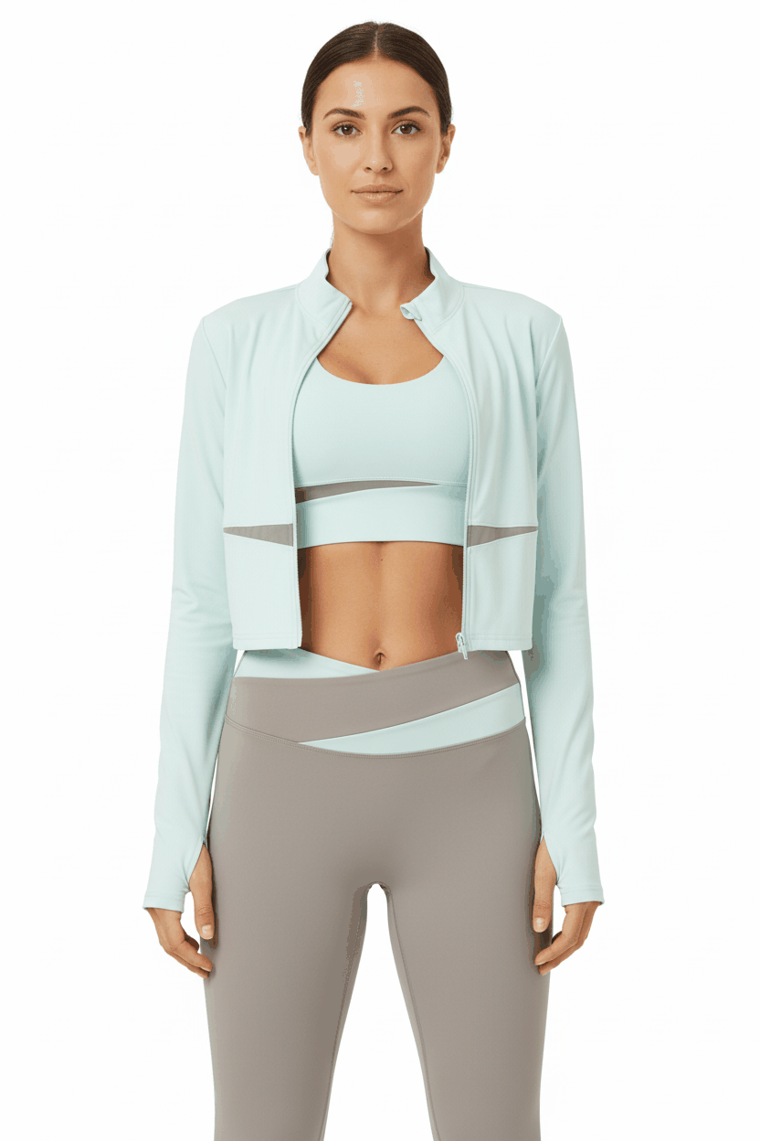 Model in mint jacket unzipped revealing mint sports bra with taupe leggings