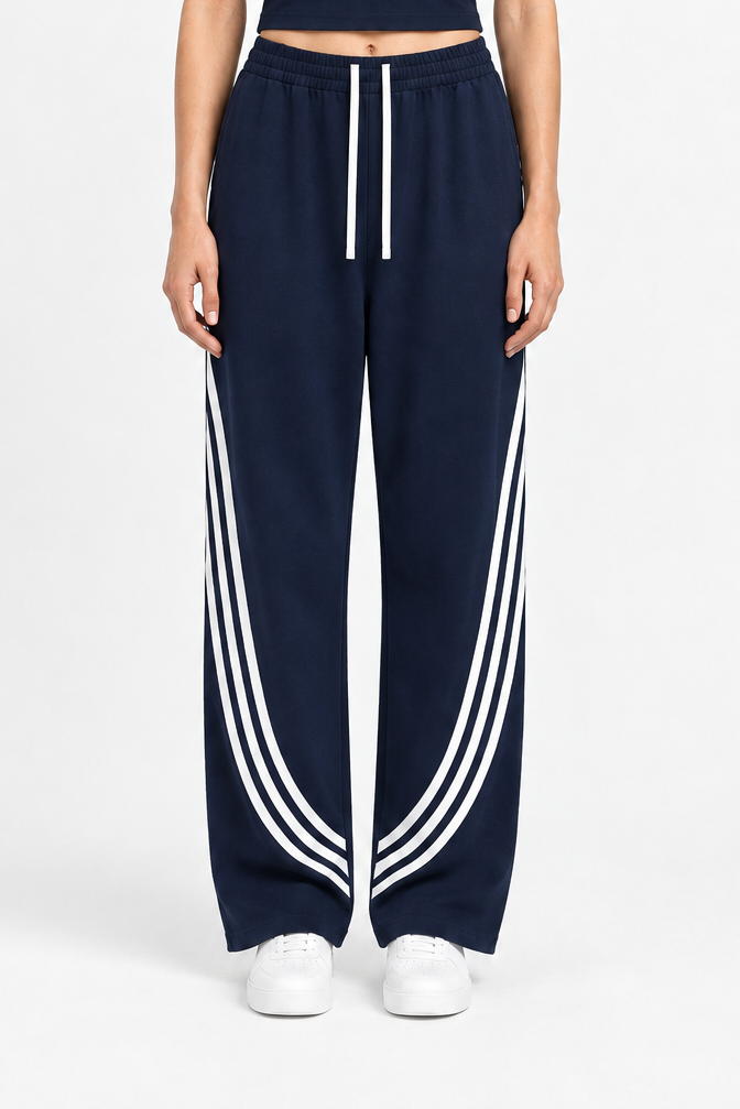 Model wearing navy ODMPOD FF Varsity Club curved stripe straight sweatpants, featuring contrasting stripe details and a comfortable fit.
