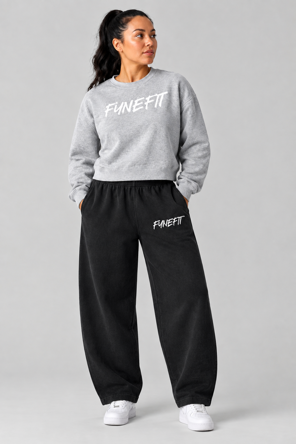 Model wearing the gray FYNEFIT sweatshirt and black barrel-leg sweatpants